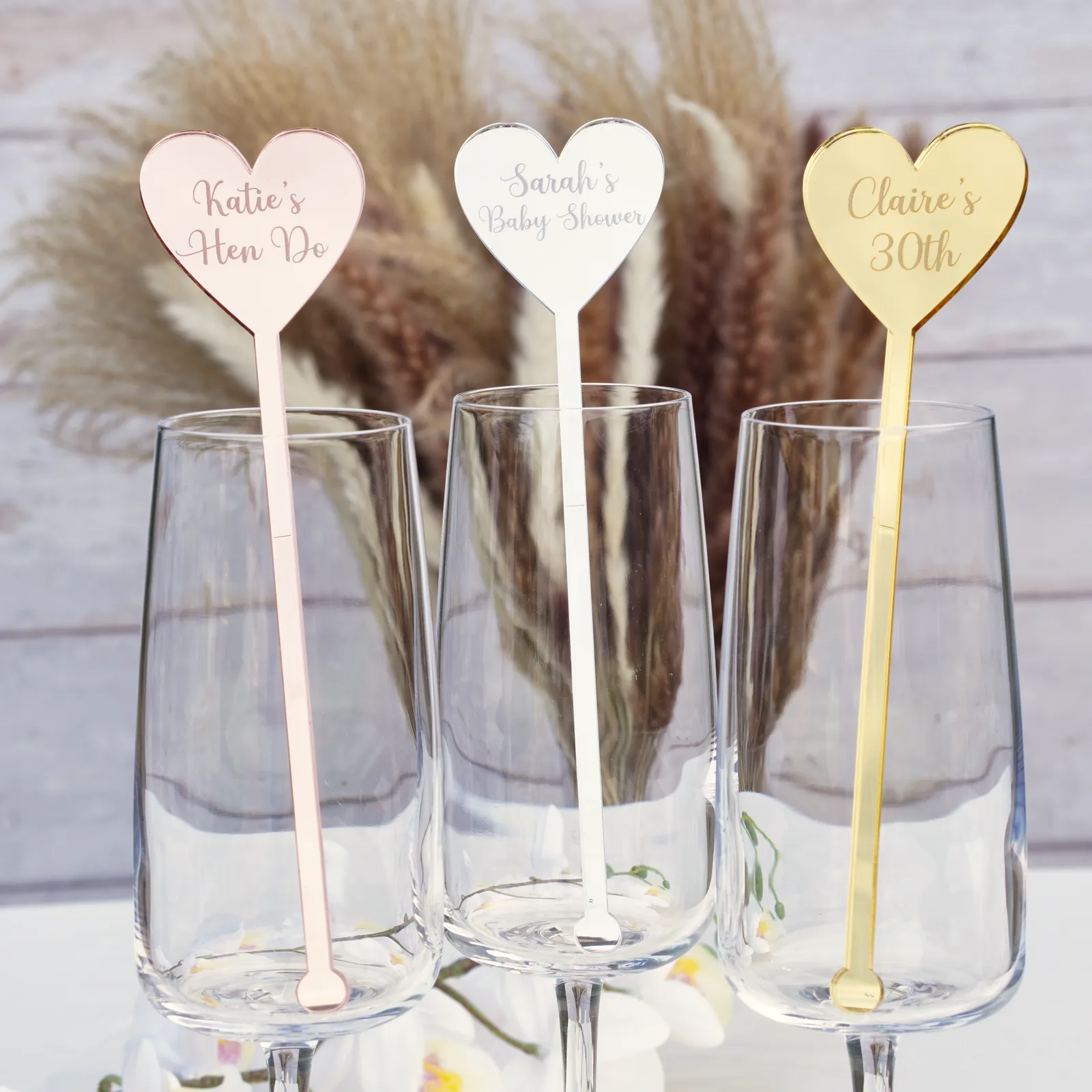 Macro of a mirror silver acrylic heart-shaped stirrer head engraved with a name